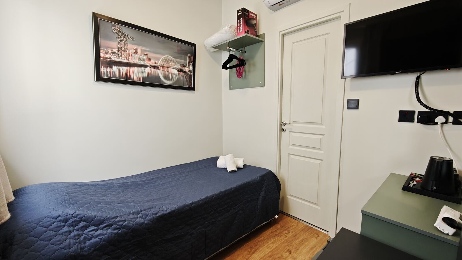 Room H8 full view with cityscape art and TV, St. Lazarus City Hotel