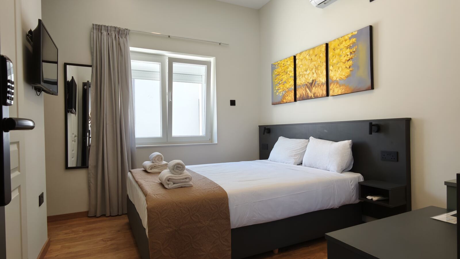 Standard double room with yellow tree triptych artwork, another instance of the shared design, St. Lazarus City Hotel