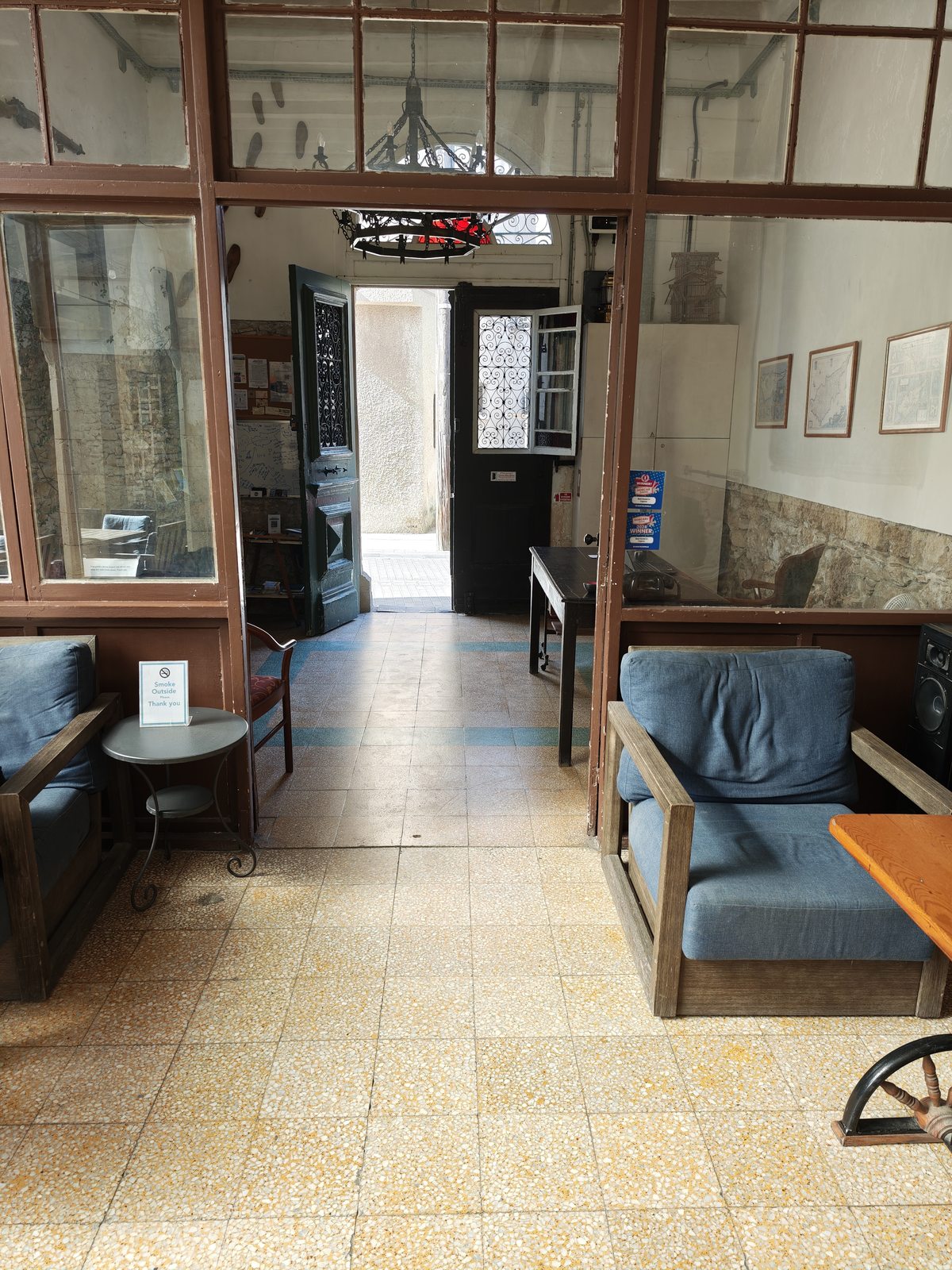 The entrance lobby at Le Mat Hostel, with the green street door open beyond