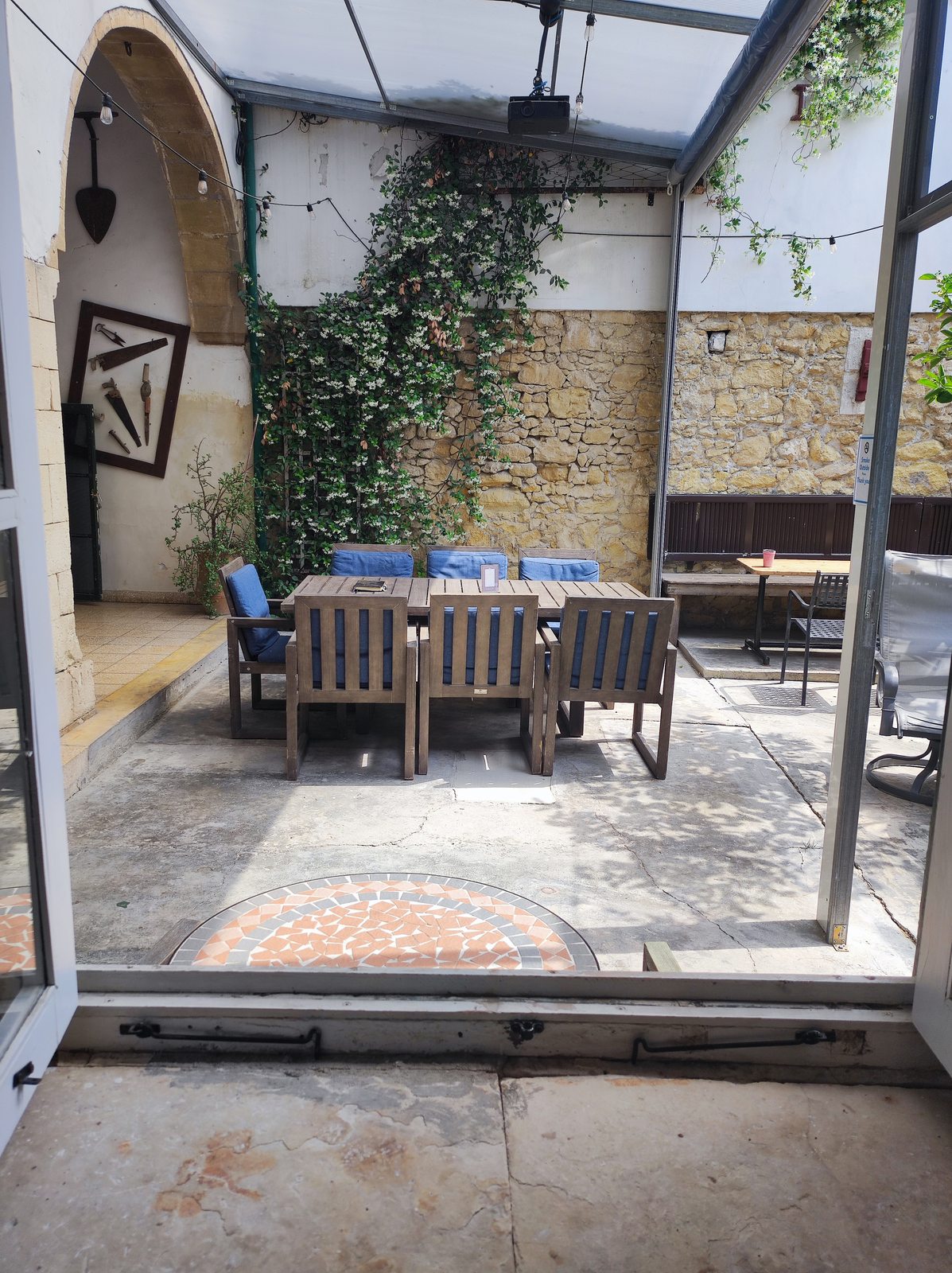 Vintage tools displayed as wall decor in the courtyard at Le Mat Hostel