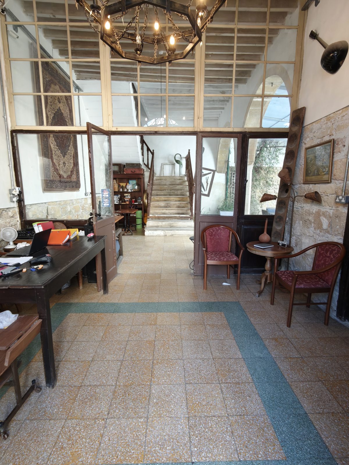 The courtyard dining area seen through an open doorway at Le Mat Hostel