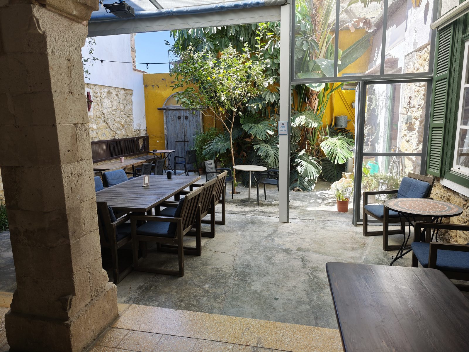 Common area near the staircase at Le Mat Hostel, with a chandelier and seating