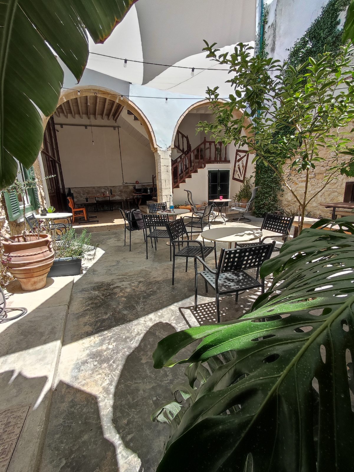 Guests relaxing in the courtyard at Le Mat Hostel during the day