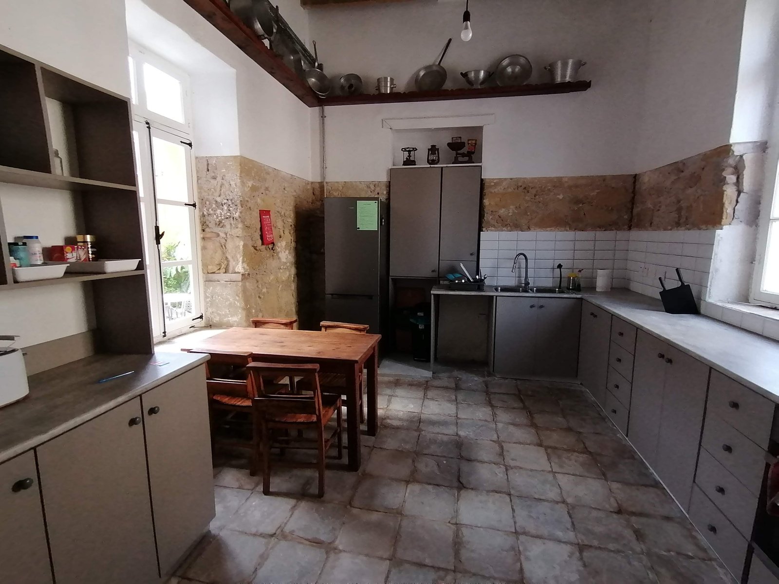 Shared kitchen with dining table, fridge, hob and cupboards