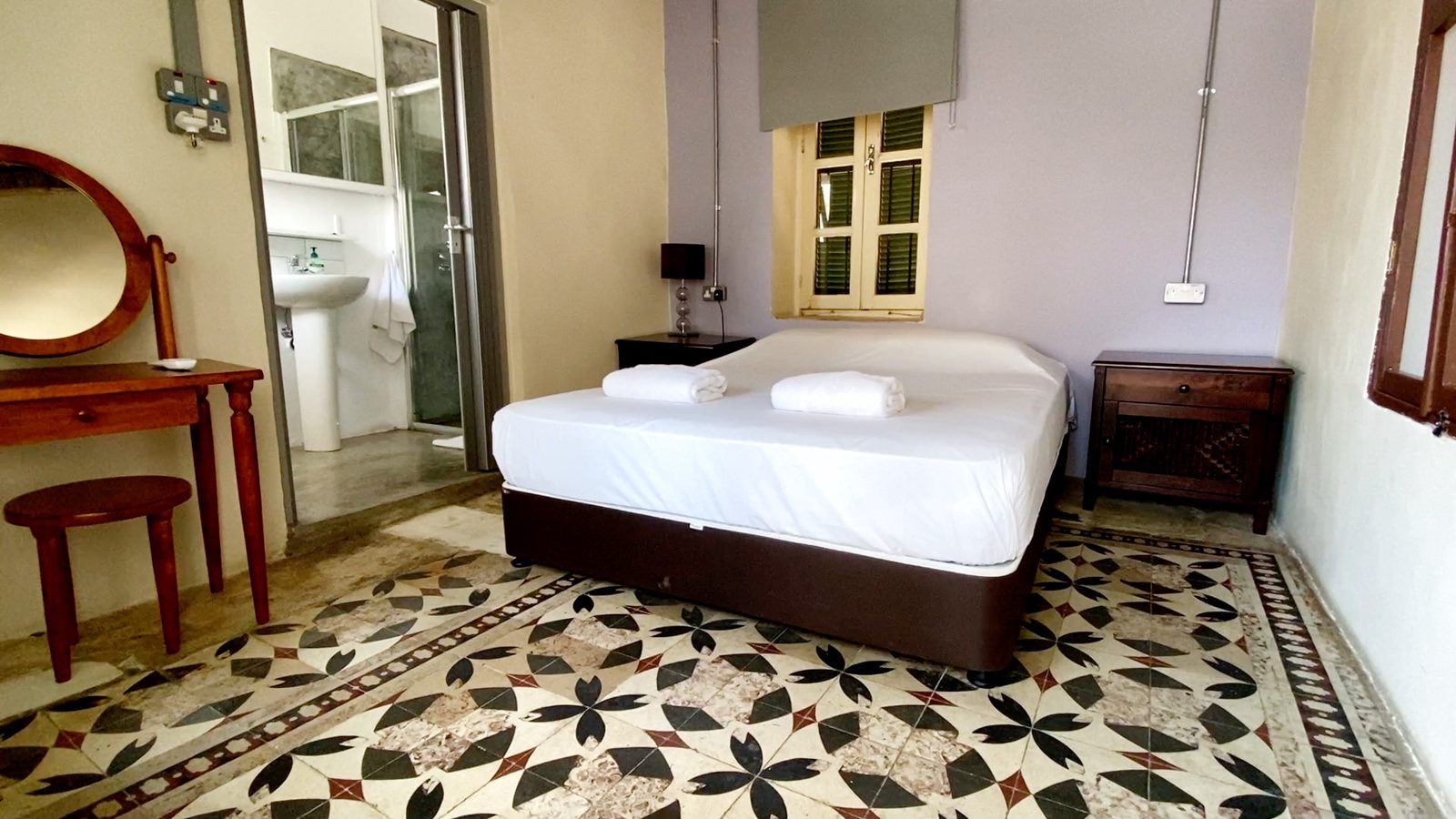 L'Amoureux private room with double bed and patterned tile floor
