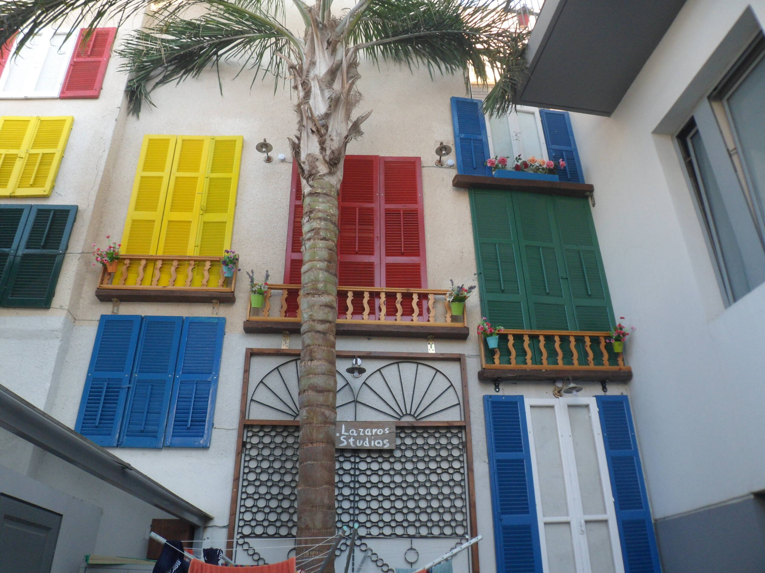 The entrance to St. Lazaros Studios, with colourful shutters and balconies above