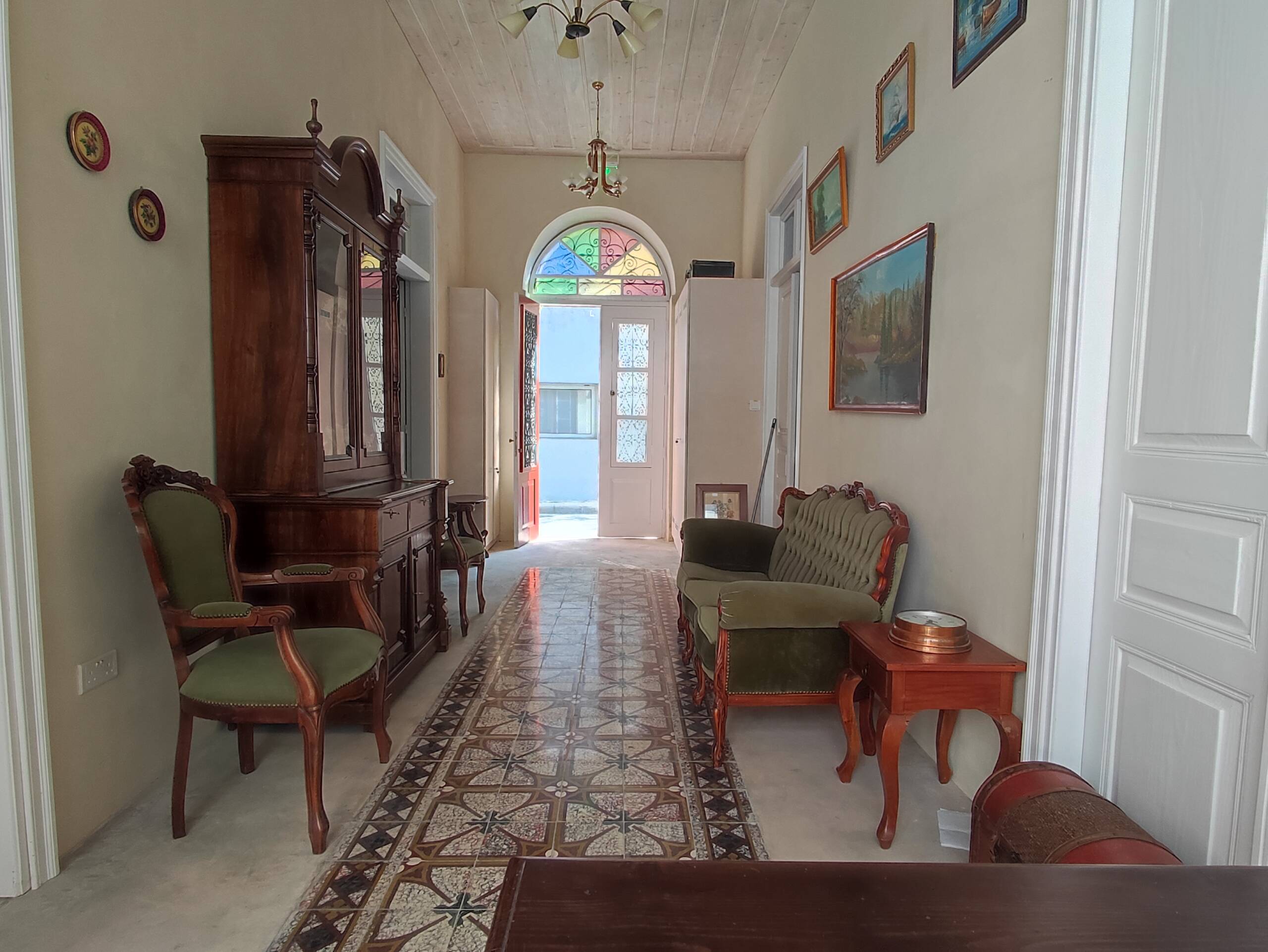 A traditional hallway at St. Lazaros Studios 2, with antique furniture and a stained-glass front door